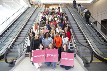 a group of women and allies taking a group picture by large staircase 