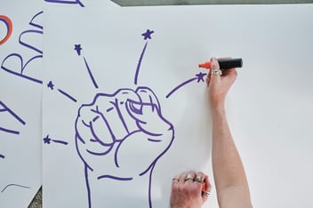 person drawing fist with marker 
