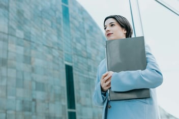 woman in suit walking with folder
