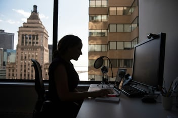 women sitting in front of desk with computer and mic 