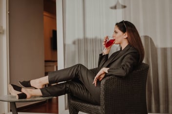 woman in black blazer sitting on a black sofa chair 