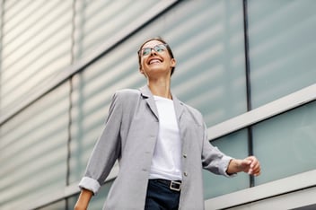 woman walking in a grey blazer