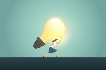 businesswoman holding up a lightbulb