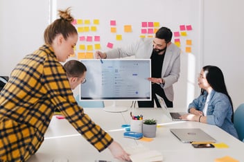 A team gathered around desk collaborating