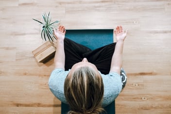 woman sitting on yoga mat with palms up