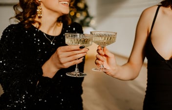 Two women tapping champagne glasses
