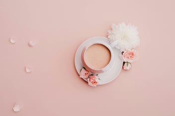 a mug with flowers on a pink background