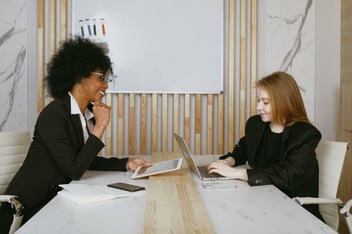 Two women collaborate at work.