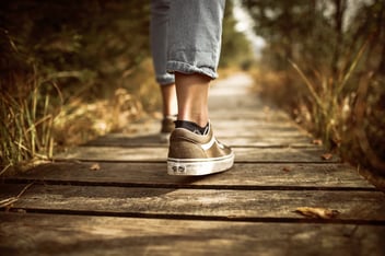 A person begins to walk down a path.
