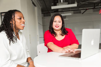 Two women looking at a laptop. 